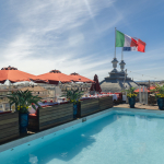 Le rooftop BCLUB du Boscolo Hôtel & Spa Nice 5 étoiles avec piscine et drapeau italien dominant les toits niçois