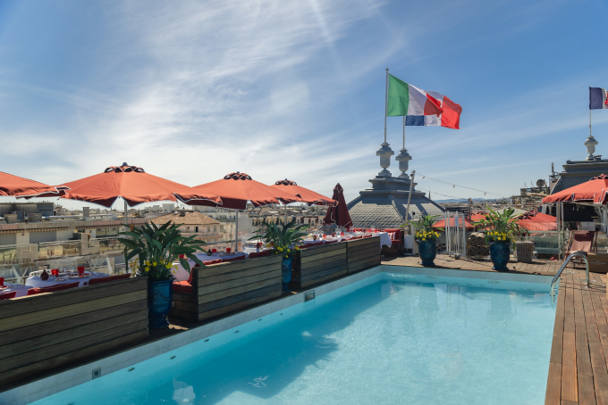 Le rooftop BCLUB du Boscolo Hôtel & Spa Nice 5 étoiles avec piscine et drapeau italien dominant les toits niçois