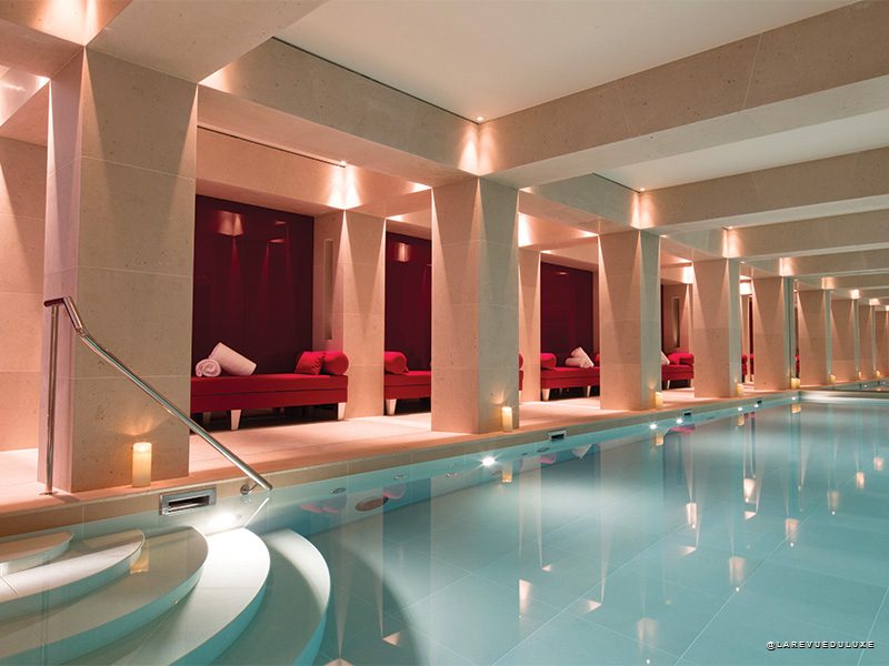 La piscine du spa de La Réserve Paris avec ses banquettes rouges emblématiques