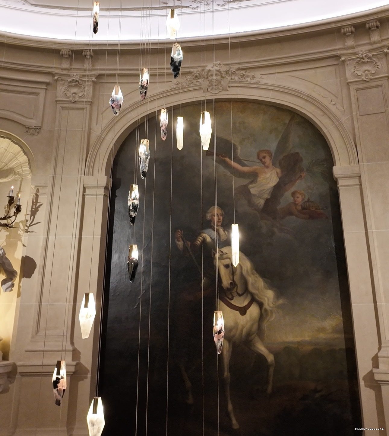 Scénographie du défilé Peet Dullaert : cristaux suspendus devant une toile équestre à l'Hôtel Wagram