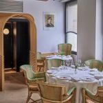 Salle du restaurant L'Arpège à Paris, fauteuils en rotin vert et tables dressées