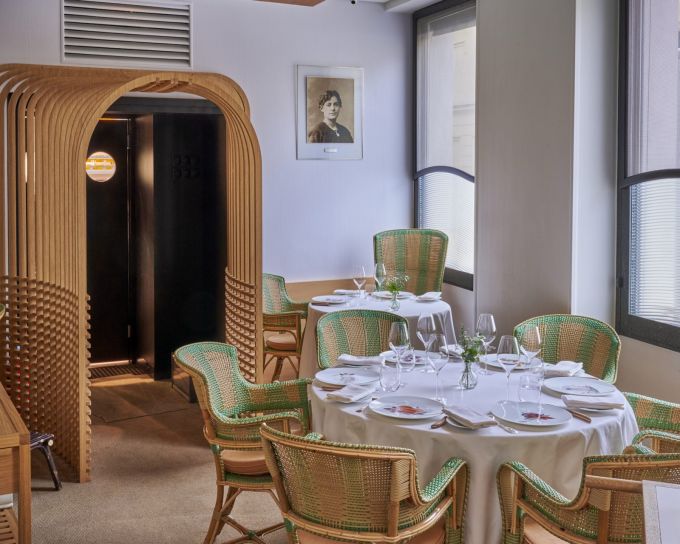 Salle du restaurant L'Arpège à Paris, fauteuils en rotin vert et tables dressées