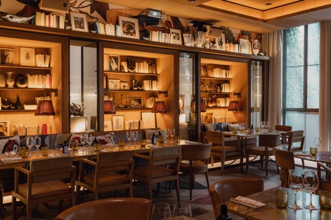 Salle du restaurant du Brach Paris, bibliothèques éclairées et tables dressées