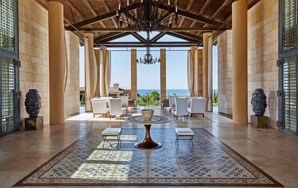 Lobby du Romanos à Costa Navarino, colonnes de pierre et vue sur la mer Ionienne