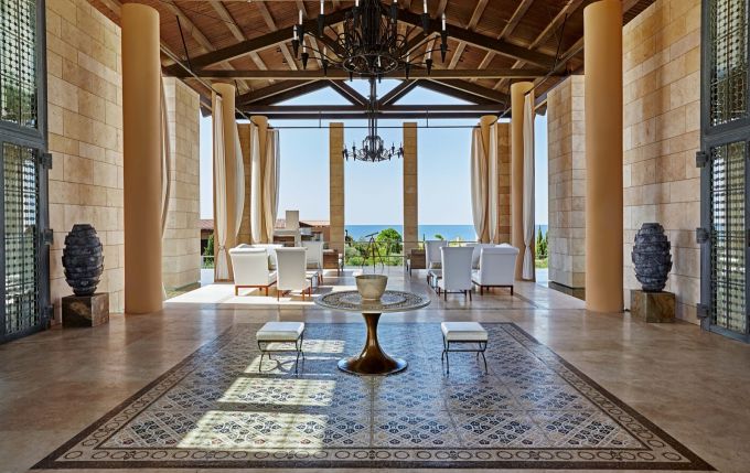 Lobby du Romanos à Costa Navarino, colonnes de pierre et vue sur la mer Ionienne