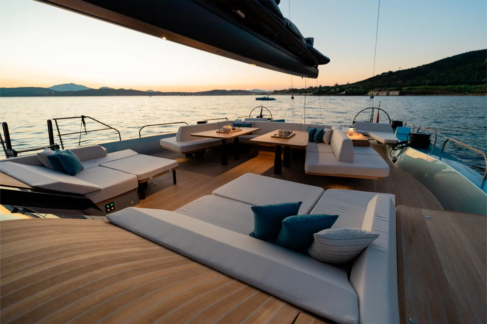 Cockpit lounge de 80 m² du Wally Wind 110 Galma au coucher du soleil, banquettes blanches et teck