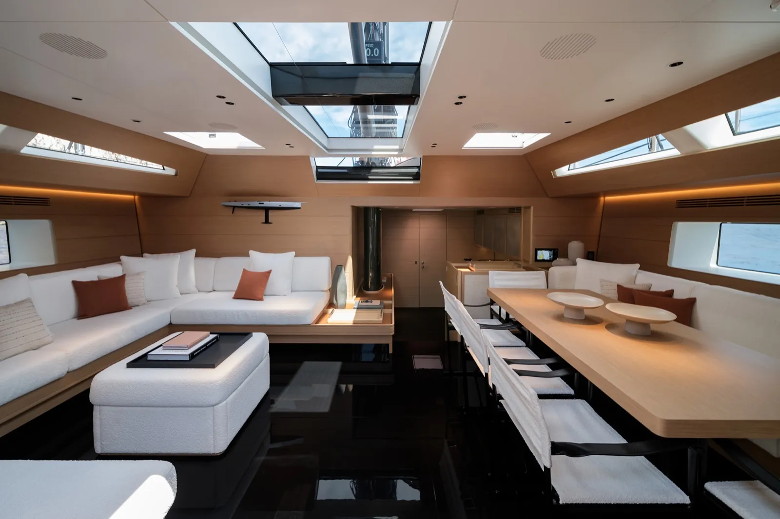 Carré intérieur du Wally Wind 110 Galma, salon en U blanc et table en bois clair