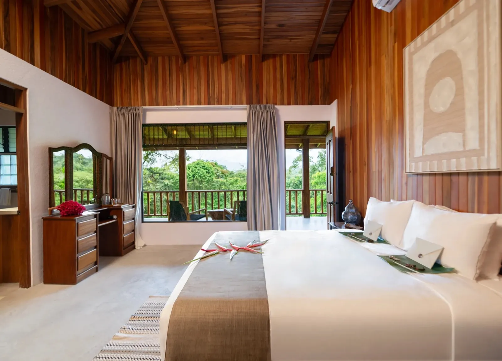 Chambre d'une villa de The Vessyl, boiseries et baie ouverte sur la forêt tropicale
