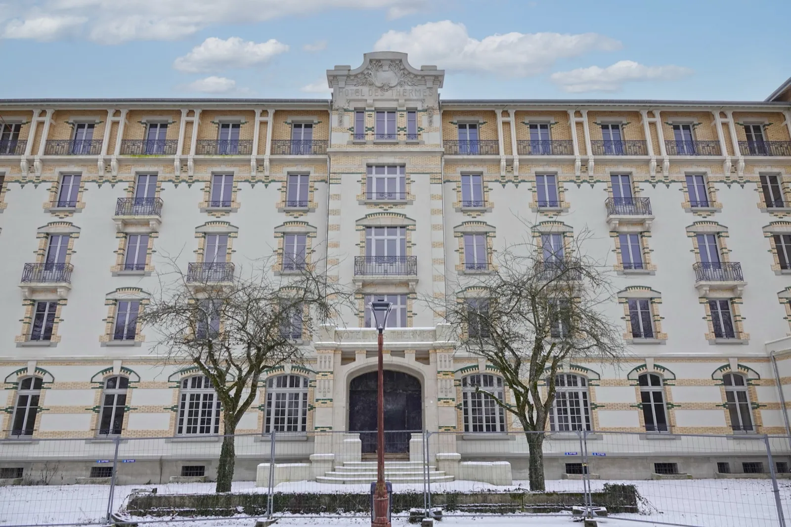 Façade de l'hôtel des Thermes à Vittel, briques et fronton sculpté, sous la neige