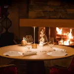 Table dressée devant la cheminée du restaurant Le Sarkara au K2 Palace de Courchevel