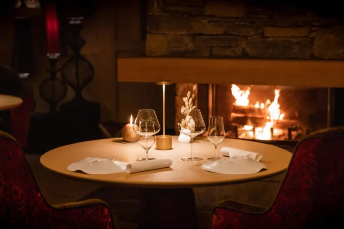 Table dressée devant la cheminée du restaurant Le Sarkara au K2 Palace de Courchevel