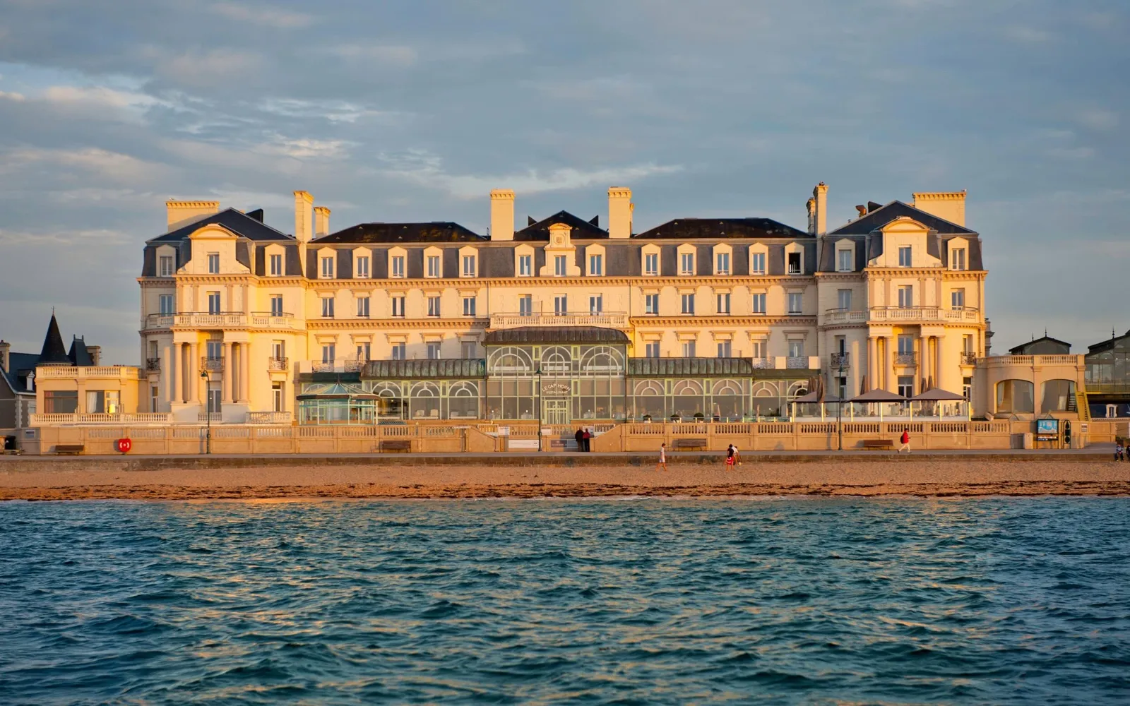Façade du Grand Hôtel des Thermes à Saint-Malo face à la plage du Sillon au soleil couchant