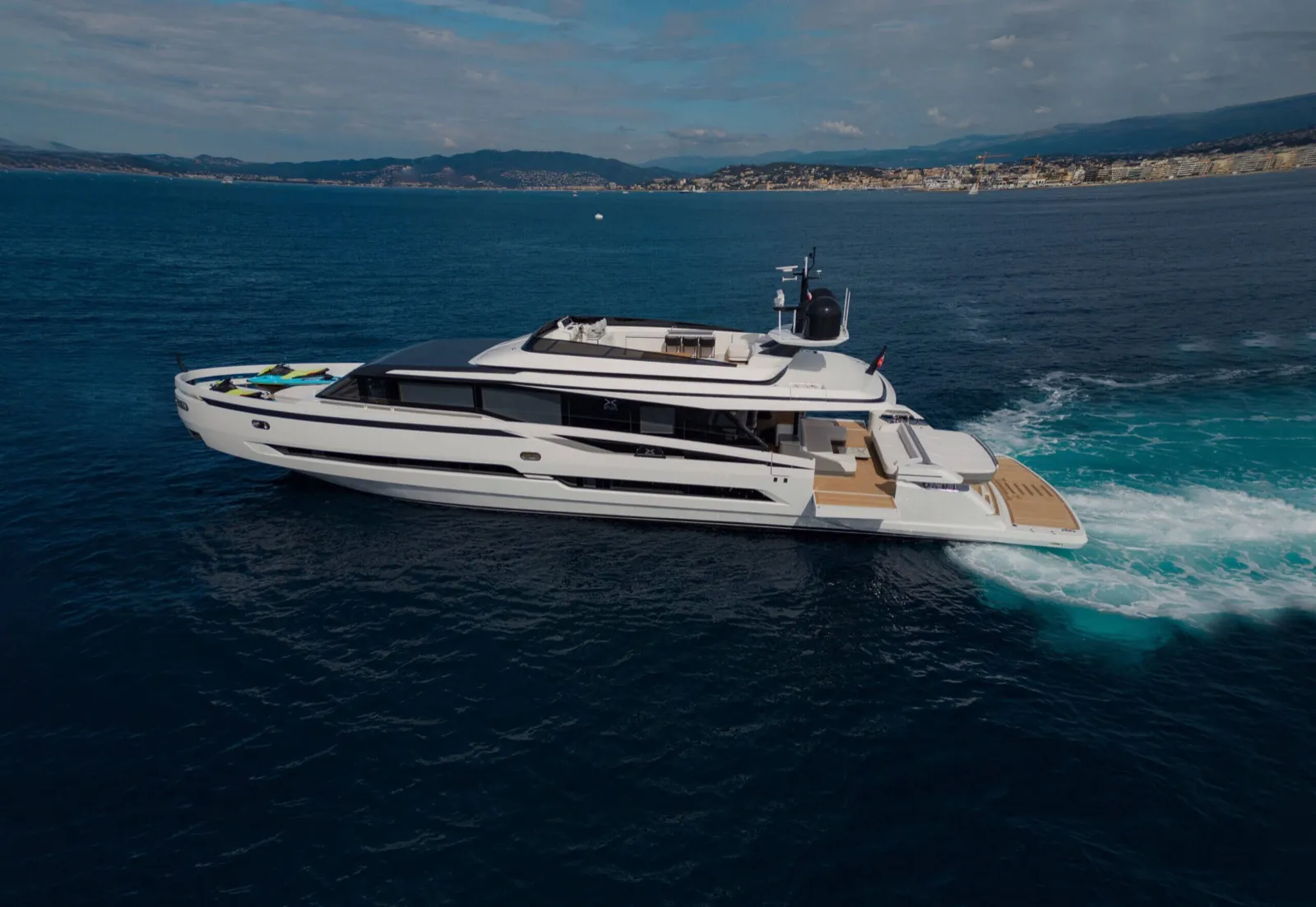 Le yacht Extra X99 Fast d'Extra Yachts lancé à pleine vitesse le long d'une côte méditerranéenne