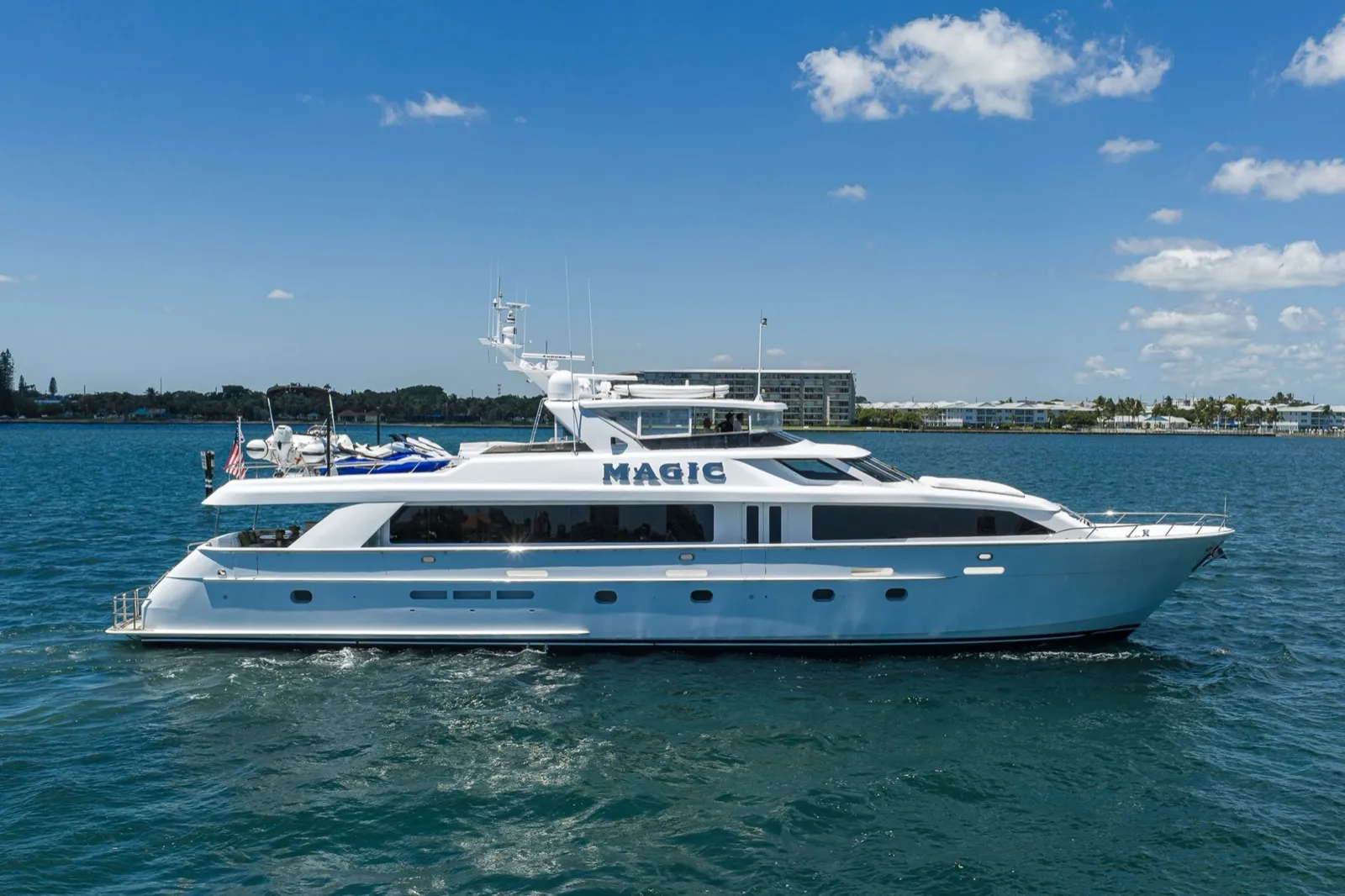 Yacht Hatteras Magic de 30 mètres naviguant de profil sous un ciel bleu en Floride