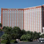Tour rouge de l'hôtel Treasure Island à Las Vegas, entourée de palmiers, vue depuis le Strip