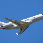 Jet d'affaires Dassault Falcon 6X en montée sous un ciel bleu lors du salon aéronautique du Bourget 2025