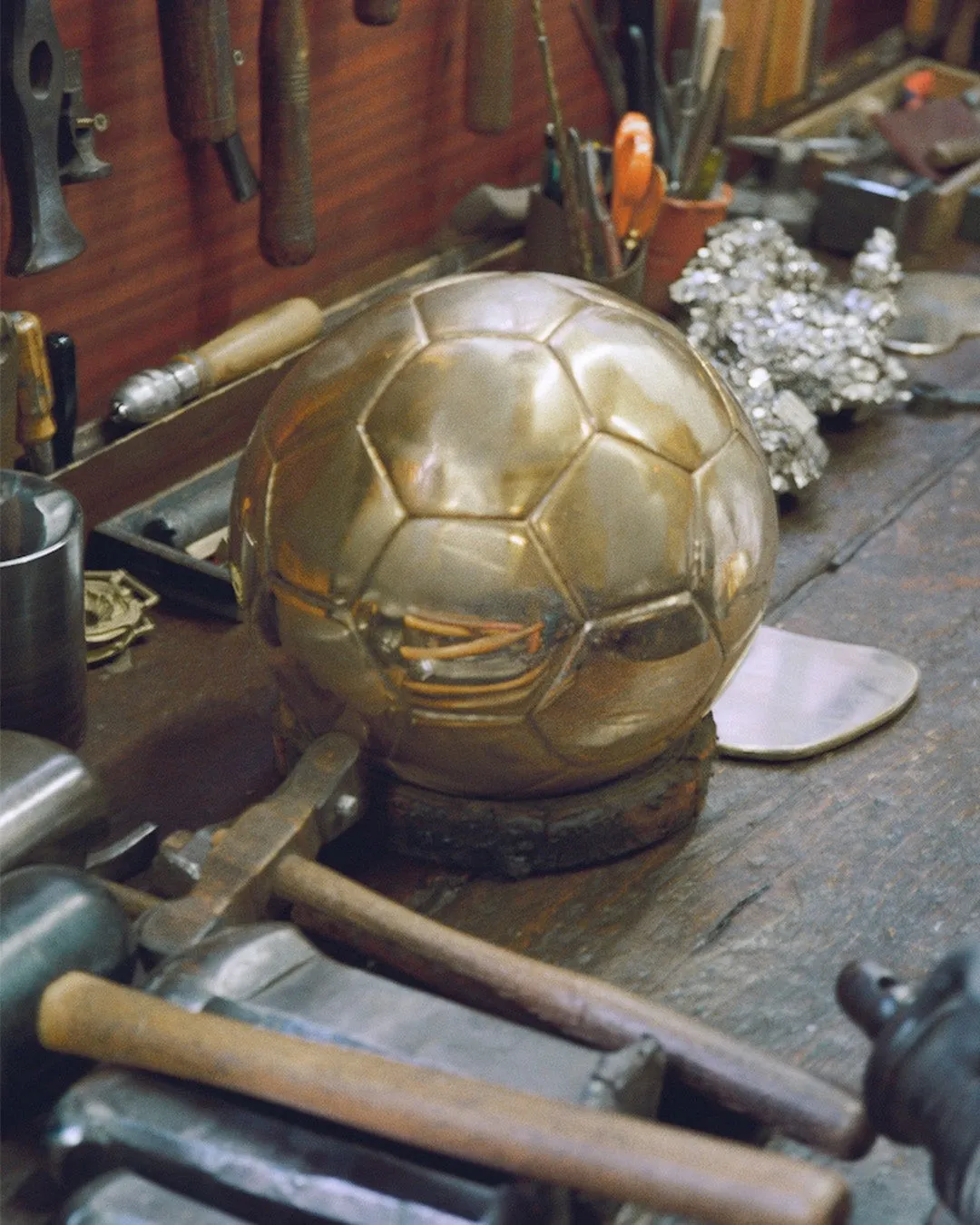 Ballon d'Or en cours de fabrication sur un établi de l'atelier Mellerio, à côté de blocs de pyrite