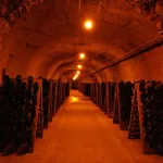 Bouteilles de champagne sur pupitres dans les caves Perrier-Jouët à Épernay