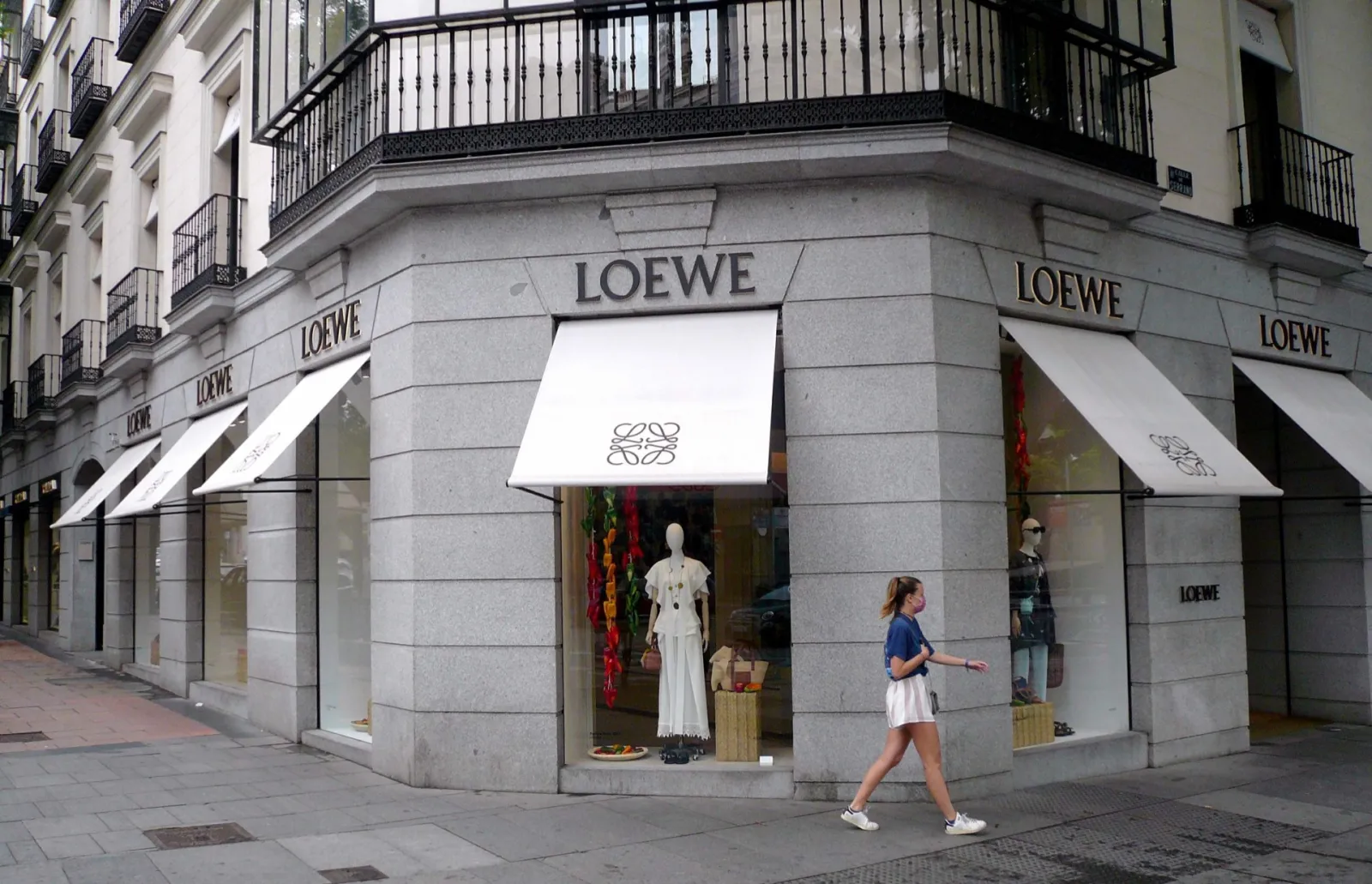 Boutique Loewe à l'angle d'un immeuble de la calle de Serrano à Madrid, vitrine avec mannequin et stores blancs