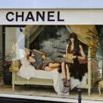 Vitrine Chanel rue Cambon à Paris, deux mannequins allongés sur une méridienne sous l'auvent blanc de la maison