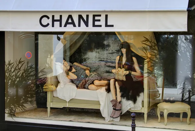 Vitrine Chanel rue Cambon à Paris, deux mannequins allongés sur une méridienne sous l'auvent blanc de la maison