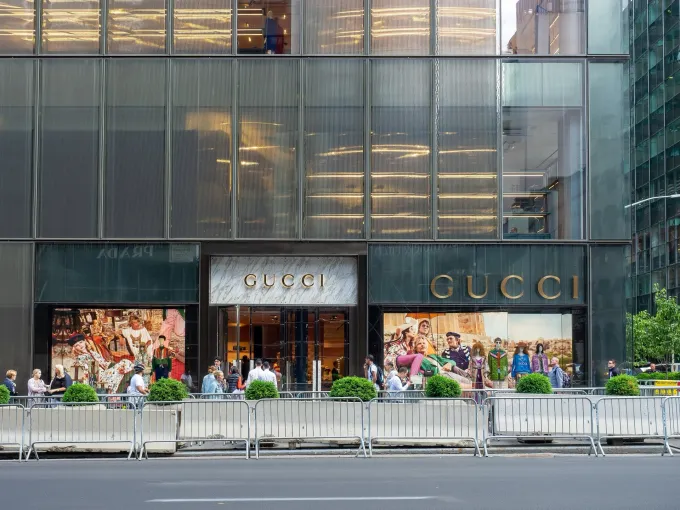 Boutique Gucci sur une grande avenue new-yorkaise, enseigne dorée et façade vitrée de l'immeuble