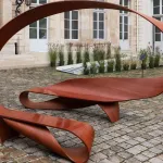 Arabesque, banc en ruban de moabi de Pierre Renart, dans la cour pavée de l'hôtel de Maisons pendant Design Miami Paris 2026