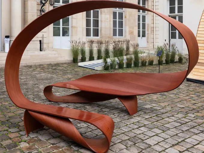 Arabesque, banc en ruban de moabi de Pierre Renart, dans la cour pavée de l'hôtel de Maisons pendant Design Miami Paris 2026