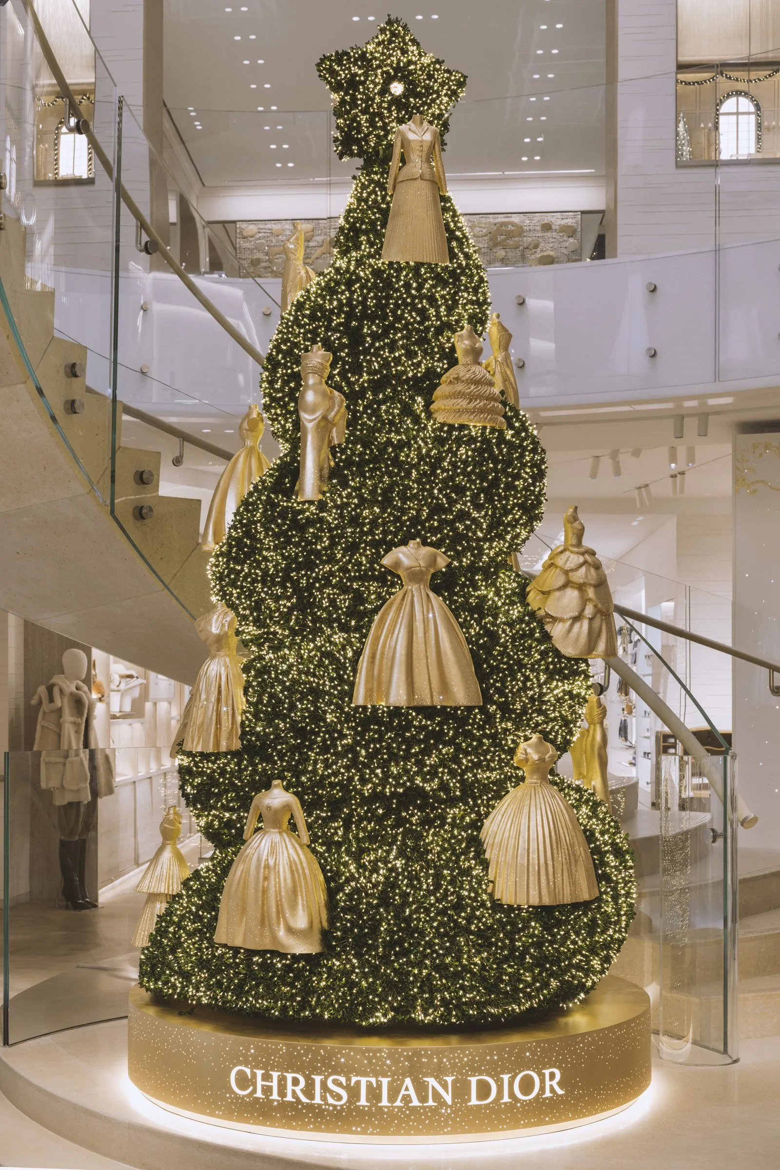Sapin de Noël du 30 Montaigne décoré de robes et de vestes Dior miniatures dorées