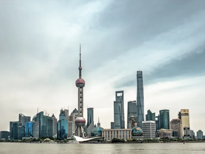 Skyline de Pudong à Shanghai, avec la tour de la Perle de l'Orient, vue depuis la rive du Huangpu sous un ciel nuageux