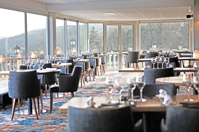 Salle du restaurant Le Panoramique du Domaine de la Corniche, tables dressées et baies vitrées sur la vallée de la Seine