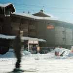 Façade en bois de l'hôtel Le Val Thorens Beaumier au pied des pistes enneigées, remontées mécaniques en arrière-plan