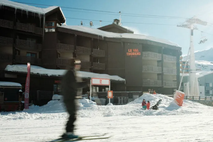 Façade en bois de l'hôtel Le Val Thorens Beaumier au pied des pistes enneigées, remontées mécaniques en arrière-plan