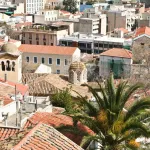 Toits de tuiles rouges et palmier sur les hauteurs d'Athènes, vue plongeante sur les maisons de la ville