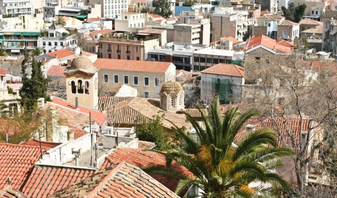 Toits de tuiles rouges et palmier sur les hauteurs d'Athènes, vue plongeante sur les maisons de la ville