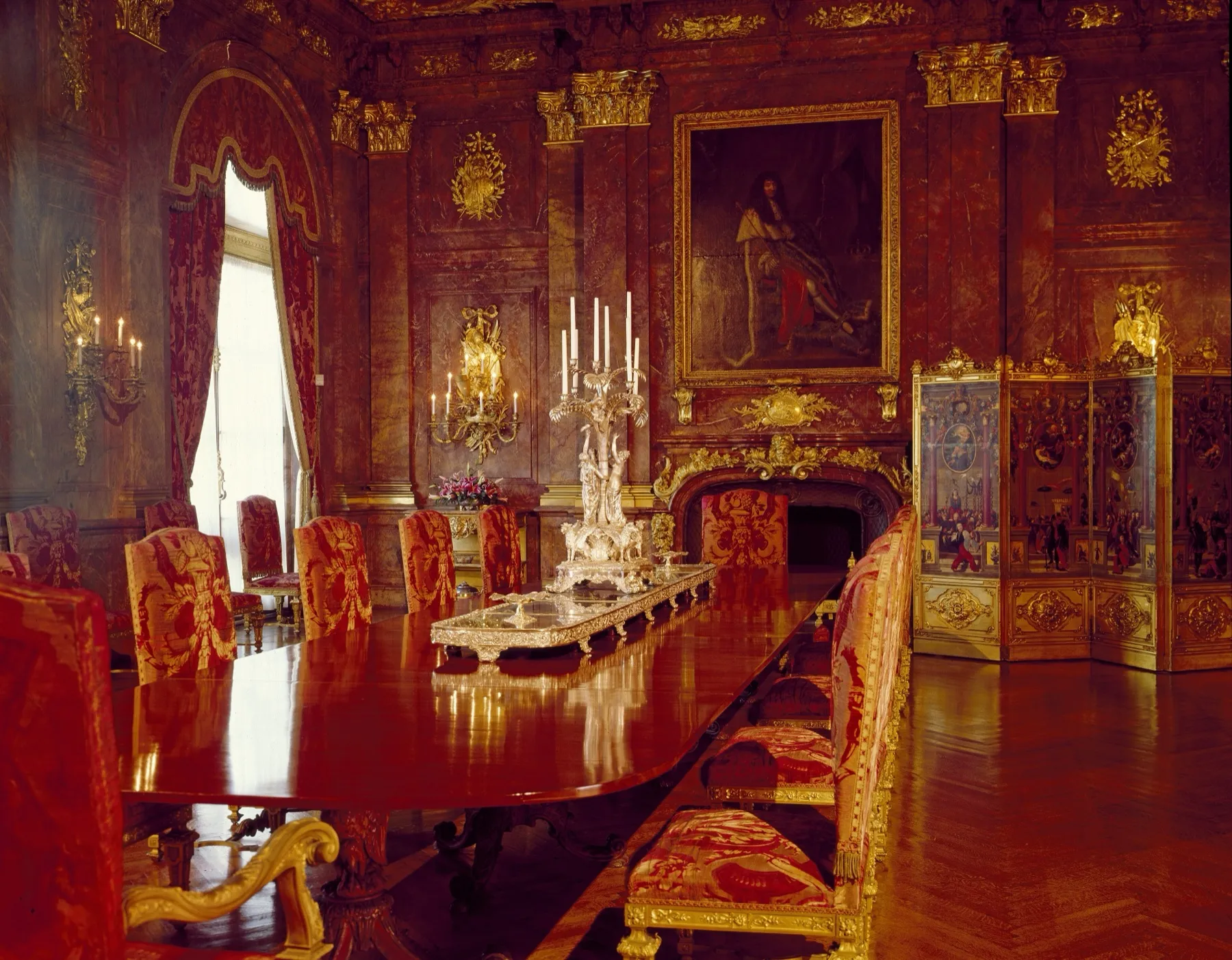 Salle à manger de Marble House à Newport, murs de marbre rose, bronzes dorés et chaises tendues de velours rouge