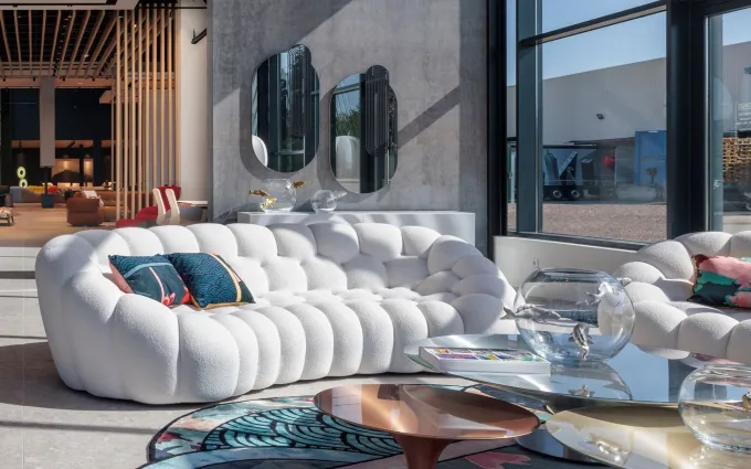 Canapé Bubble blanc, miroirs ovales et larges baies vitrées dans le showroom Roche Bobois de Saint-Bonnet-de-Mure