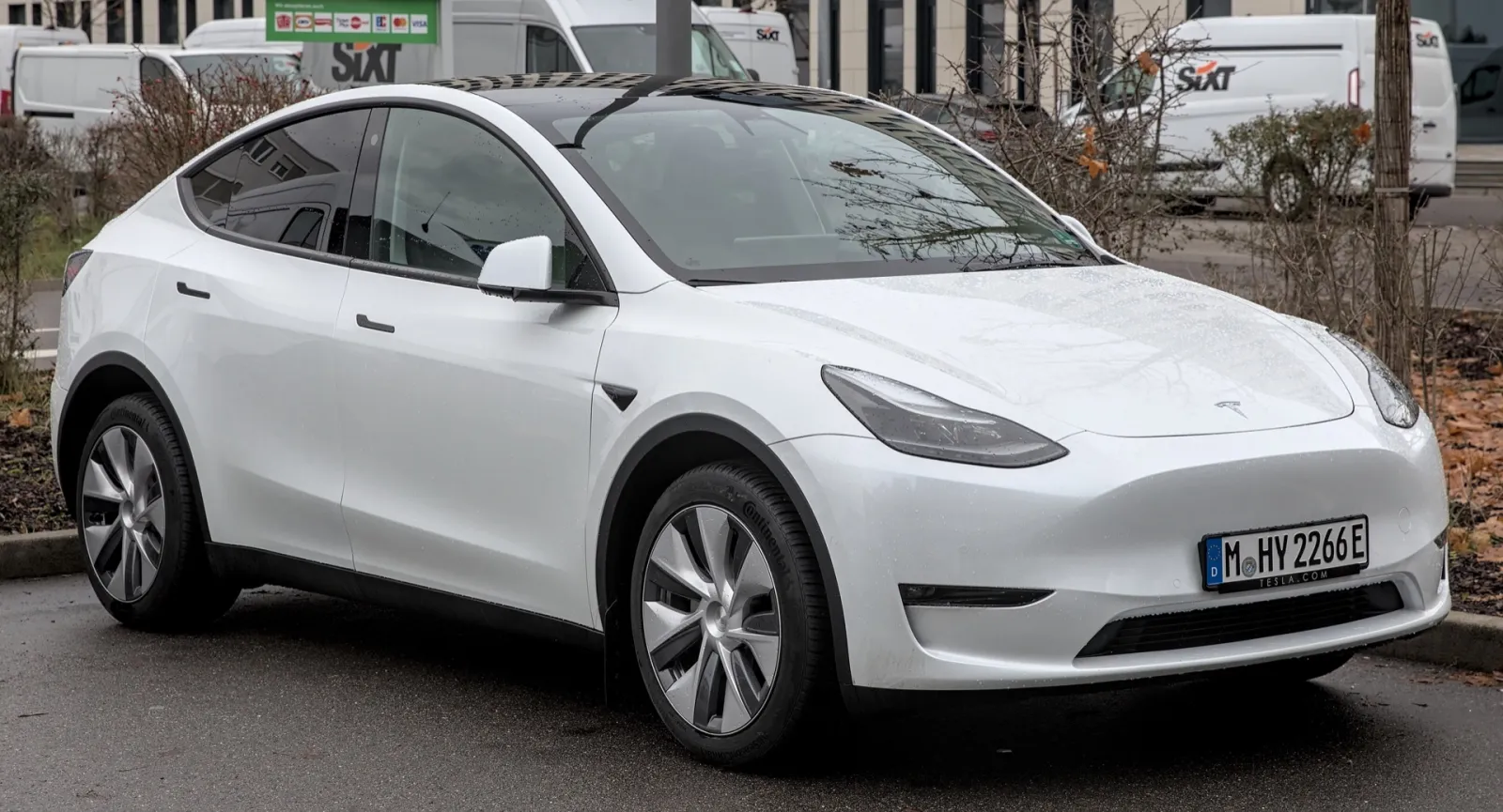 SUV électrique Tesla Model Y de couleur blanche garé dans une rue, vu de trois quarts avant