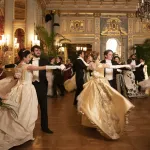 Danseurs en robes de bal et habits dans le Music Room doré de The Breakers, scène de bal de The Gilded Age