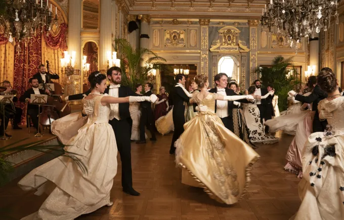 Danseurs en robes de bal et habits dans le Music Room doré de The Breakers, scène de bal de The Gilded Age