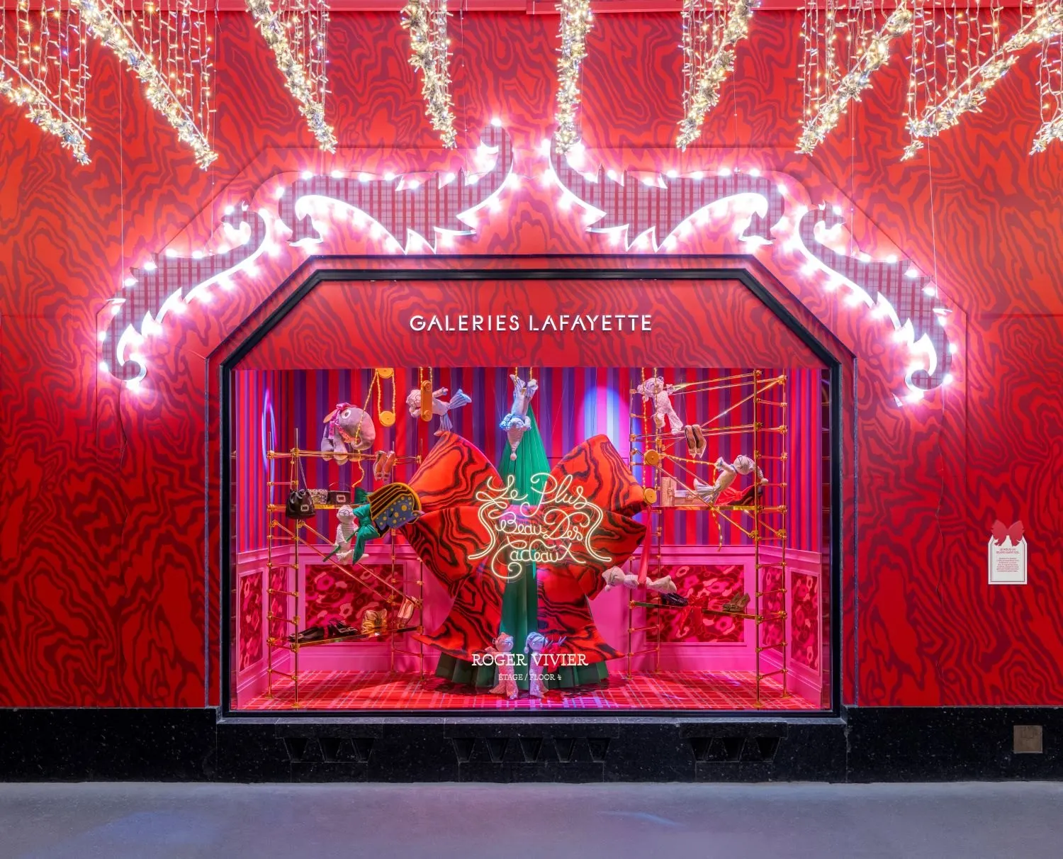 Vitrine animée des Galeries Lafayette en 2025 avec des personnages de Noël sous des guirlandes lumineuses